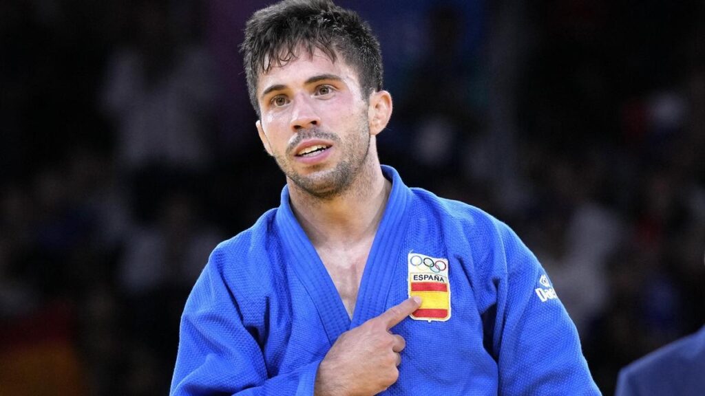 Judoka español señalando la bandera de españa
Japonés