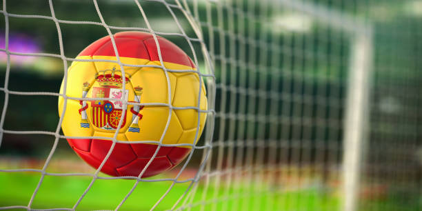 Un balón de fútbol con la bandera de España está en la red.
TAD