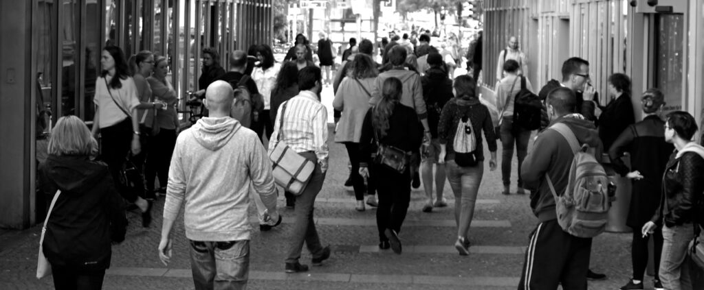 Foto en blanco y negro de personas caminando por la calle.
Estudio