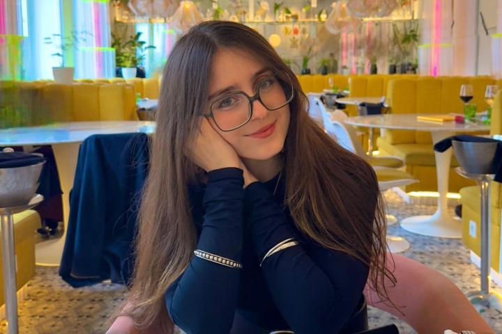 Una mujer con gafas sentada en una mesa de restaurante.